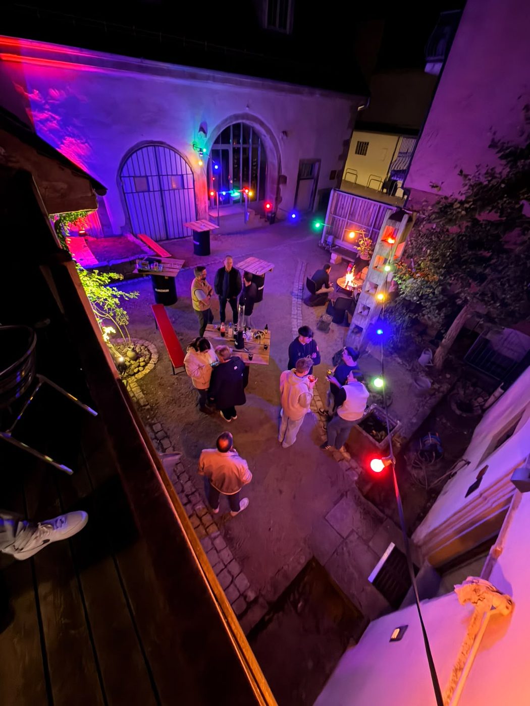 Gäste im beleuchteten Innenhof, von oben fotografiert