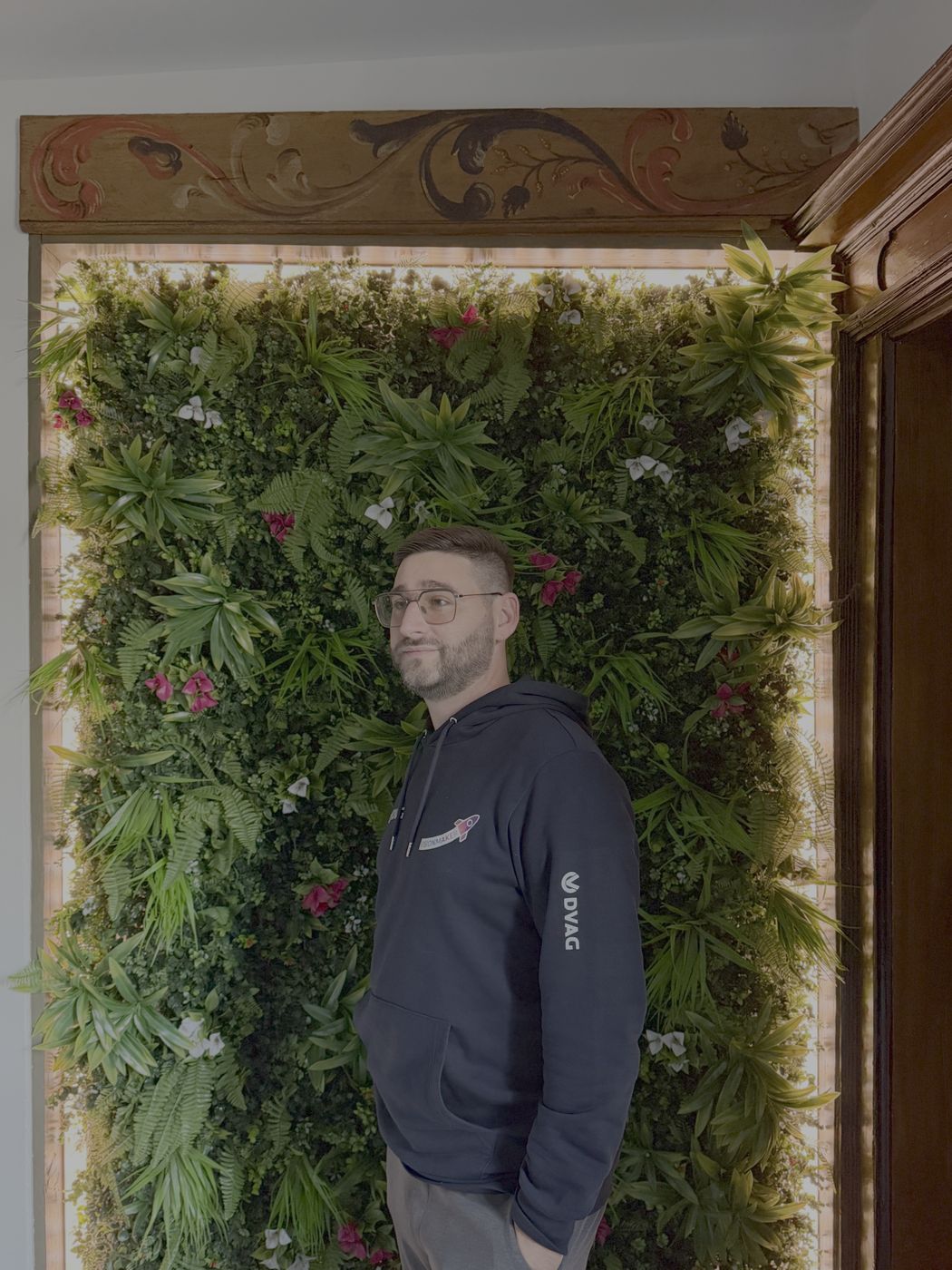 Christopher Kopp vor der Pflanzenwand im neuen Büro